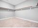 Empty walk-in closet with a neutral carpet and multiple shelves and closet rods at 948 Uprock Dr, Cary, NC 27519