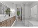 Modern bathroom with a double vanity, a glass shower, and an open doorway to the bedroom at 949 Harrison Ridge Rd, Wake Forest, NC 27587