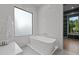 Modern bathroom featuring a large window, a soaking tub, and marble-style tiles at 949 Harrison Ridge Rd, Wake Forest, NC 27587