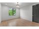 Bright bedroom featuring light wood floors, modern lighting, and a scenic outdoor view from the window at 949 Harrison Ridge Rd, Wake Forest, NC 27587