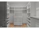 Walk-in closet featuring custom shelving, ample storage space, and stylish wood flooring at 949 Harrison Ridge Rd, Wake Forest, NC 27587