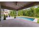 A covered patio includes a ceiling fan, a built-in grill, and a serene view of the backyard pool at 949 Harrison Ridge Rd, Wake Forest, NC 27587