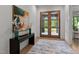 Inviting foyer featuring modern artwork, stylish decor, and beautiful wood double doors at 949 Harrison Ridge Rd, Wake Forest, NC 27587
