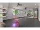 Home gym featuring rubber flooring, large mirrors, custom shelving and plenty of natural light at 949 Harrison Ridge Rd, Wake Forest, NC 27587