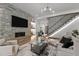 Comfortable living room featuring a stone fireplace, modern lighting, and a staircase at 949 Harrison Ridge Rd, Wake Forest, NC 27587
