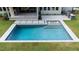 Backyard pool with a fountain and shallow entrance sits amidst green grass, offering a refreshing retreat at 949 Harrison Ridge Rd, Wake Forest, NC 27587