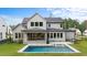 Rear view of home with a backyard pool, patio, built in grill, and a lush green lawn at 949 Harrison Ridge Rd, Wake Forest, NC 27587