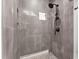 Elegant walk-in shower featuring dark hardware, gray textured tiling, and a convenient built-in shower niche at 949 Harrison Ridge Rd, Wake Forest, NC 27587