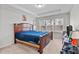 Primary bedroom boasts large windows and a dark wood frame bed at 987 Parkstone Towne Blvd, Knightdale, NC 27545
