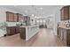 Open-concept kitchen boasts granite countertops, stainless steel appliances, wood cabinets, and wood-look flooring at 987 Parkstone Towne Blvd, Knightdale, NC 27545