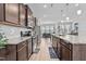 Open-concept kitchen boasts granite countertops, stainless steel appliances, wood cabinets, and subway tile backsplash at 987 Parkstone Towne Blvd, Knightdale, NC 27545