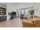Cozy living room features a plush sectional sofa, entertainment center, and natural light from large windows at 987 Parkstone Towne Blvd, Knightdale, NC 27545