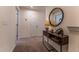 Warm and inviting entryway featuring a stylish console table, round mirror, and soft lighting at Lot 5 Cooper St, Sanford, NC 27330
