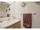 Neutral toned bathroom features light wood vanity, sink, and decorative wall art at 10 Grove Park Rd, Durham, NC 27705