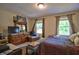 Bright bedroom with warm neutral walls, natural light, bed, chair, and wooden furniture at 10 Grove Park Rd, Durham, NC 27705