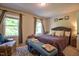 Well lit bedroom with two windows, plush rug, full bed, and bench seating at 10 Grove Park Rd, Durham, NC 27705