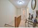 Hallway featuring neutral walls, wooden railing and decorative table with mirror at 10 Grove Park Rd, Durham, NC 27705