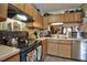 Kitchen showcasing wood cabinetry, stainless steel dishwasher, and black electric stove at 10 Grove Park Rd, Durham, NC 27705