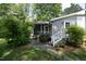 Charming back entrance with a screened porch and stone pathway, surrounded by greenery at 1004 Greenwich St, Raleigh, NC 27610