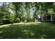 Expansive backyard with mature trees, lush lawn, and a shed, perfect for outdoor activities and relaxation at 1004 Greenwich St, Raleigh, NC 27610