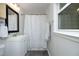 Cozy bathroom with a white vanity, updated fixtures, a shower with a patterned curtain, and a large window at 1004 Greenwich St, Raleigh, NC 27610