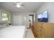 Bright bedroom featuring hardwood floors, a ceiling fan, and a large dresser with a sailboat-themed television at 1004 Greenwich St, Raleigh, NC 27610