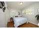 Comfortable bedroom featuring hardwood floors, two windows with blinds, and a queen bed with blue bedding at 1004 Greenwich St, Raleigh, NC 27610