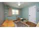 bedroom featuring an accent wall, hardwood floors, a window, and an adorable toddler bed at 1004 Greenwich St, Raleigh, NC 27610