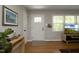 Bright entryway with hardwood floors, white door, and view of living room at 1004 Greenwich St, Raleigh, NC 27610