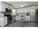 Bright kitchen with white cabinets, stainless appliances, granite countertops, and gray tile floor at 1004 Greenwich St, Raleigh, NC 27610