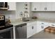 The bright, updated kitchen features white cabinets, granite countertops, and stainless appliances at 1004 Greenwich St, Raleigh, NC 27610