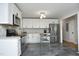 Bright kitchen features white cabinets, stainless appliances, granite countertops and gray tile floor at 1004 Greenwich St, Raleigh, NC 27610
