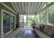 Screened porch with comfortable seating and peaceful views of lush greenery at 1004 Greenwich St, Raleigh, NC 27610