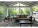 Covered porch with wicker furniture, neutral colored cushions, and a view of the yard at 1004 Greenwich St, Raleigh, NC 27610