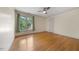 Bedroom with hardwood floors, ceiling fan, and ample natural light from the large window at 101 Abbotsford Ct, Durham, NC 27712