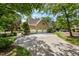 Spacious three-car garage with a large driveway surrounded by mature trees and landscaping at 101 Abbotsford Ct, Durham, NC 27712