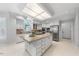 Spacious kitchen featuring white cabinets, a granite island, stainless steel appliances, and ample lighting at 101 Abbotsford Ct, Durham, NC 27712