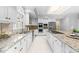 Elegant kitchen boasts granite counters, white cabinetry, stainless steel appliances, and tiled floors at 101 Abbotsford Ct, Durham, NC 27712