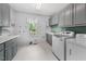 Functional laundry room with modern appliances, storage cabinets, and a window for natural light at 101 Abbotsford Ct, Durham, NC 27712