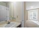 Well-lit bathroom with a single sink vanity and view into bedroom with large window at 101 Pickett Ln, Cary, NC 27511