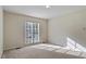 Neutral bedroom featuring a large window and carpeted floors at 101 Pickett Ln, Cary, NC 27511