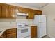 Efficient kitchen with wood cabinets and essential appliances at 101 Pickett Ln, Cary, NC 27511
