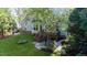 An aerial view of a lush backyard with a wooden deck, a stone patio seating area, and meticulously maintained landscaping at 101 Worsham Dr, Chapel Hill, NC 27516