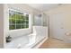 Bathroom with soaking tub under a bright window and glass-enclosed shower at 101 Worsham Dr, Chapel Hill, NC 27516