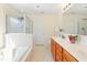 Bright bathroom featuring a double vanity, bathtub, and glass-enclosed shower at 101 Worsham Dr, Chapel Hill, NC 27516