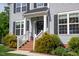 Close up of the front porch featuring brick stairs, white railings, and lush landscaping at 101 Worsham Dr, Chapel Hill, NC 27516