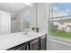 Bathroom with a white countertop, dark cabinets, and a large mirror, and natural light at 1016 Pemberly Ave, Morrisville, NC 27560