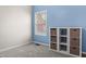 Bright bedroom featuring blue accent wall, neutral carpet, and a storage unit with natural fiber drawers at 1016 Pemberly Ave, Morrisville, NC 27560