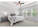 Cozy bedroom featuring a ceiling fan, a tray ceiling, neutral walls, and natural light from the window at 1016 Pemberly Ave, Morrisville, NC 27560