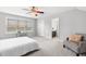 Main bedroom features natural light, carpet, sitting bench, a ceiling fan, and view to the ensuite bathroom at 1016 Pemberly Ave, Morrisville, NC 27560